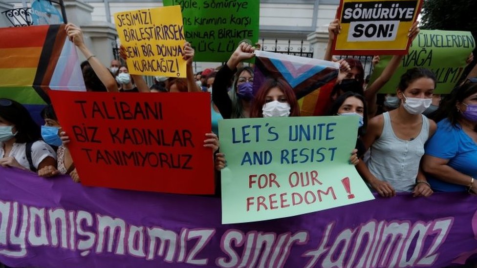 Activists hold placards saying 