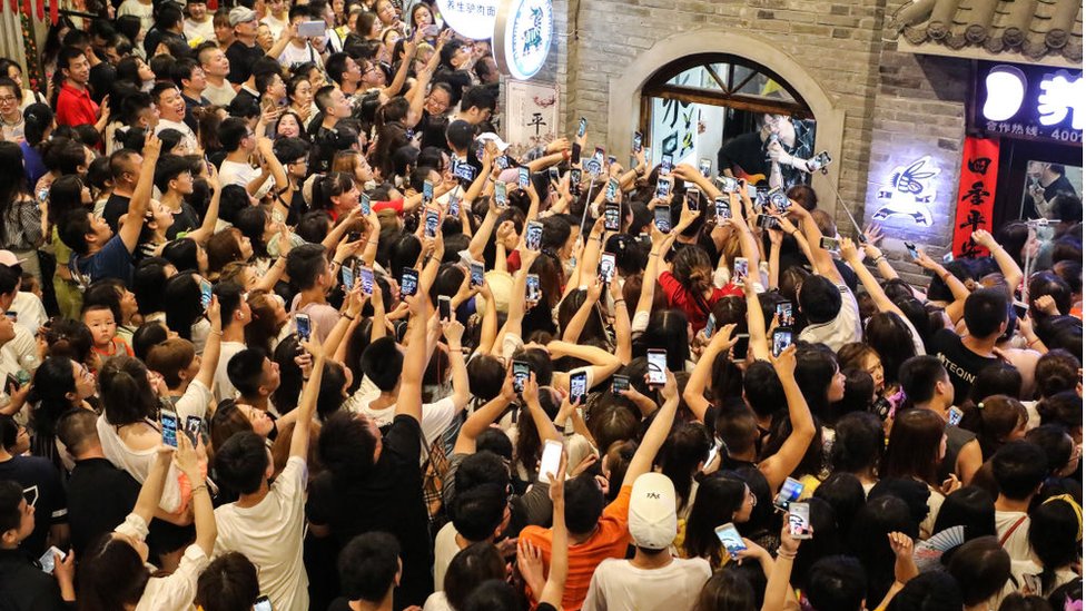 Penggemar merekam aksi boy band Modern Brothers di Dandong, China.