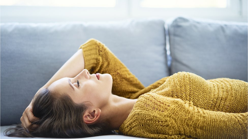 Perempuan berbaring di sofa